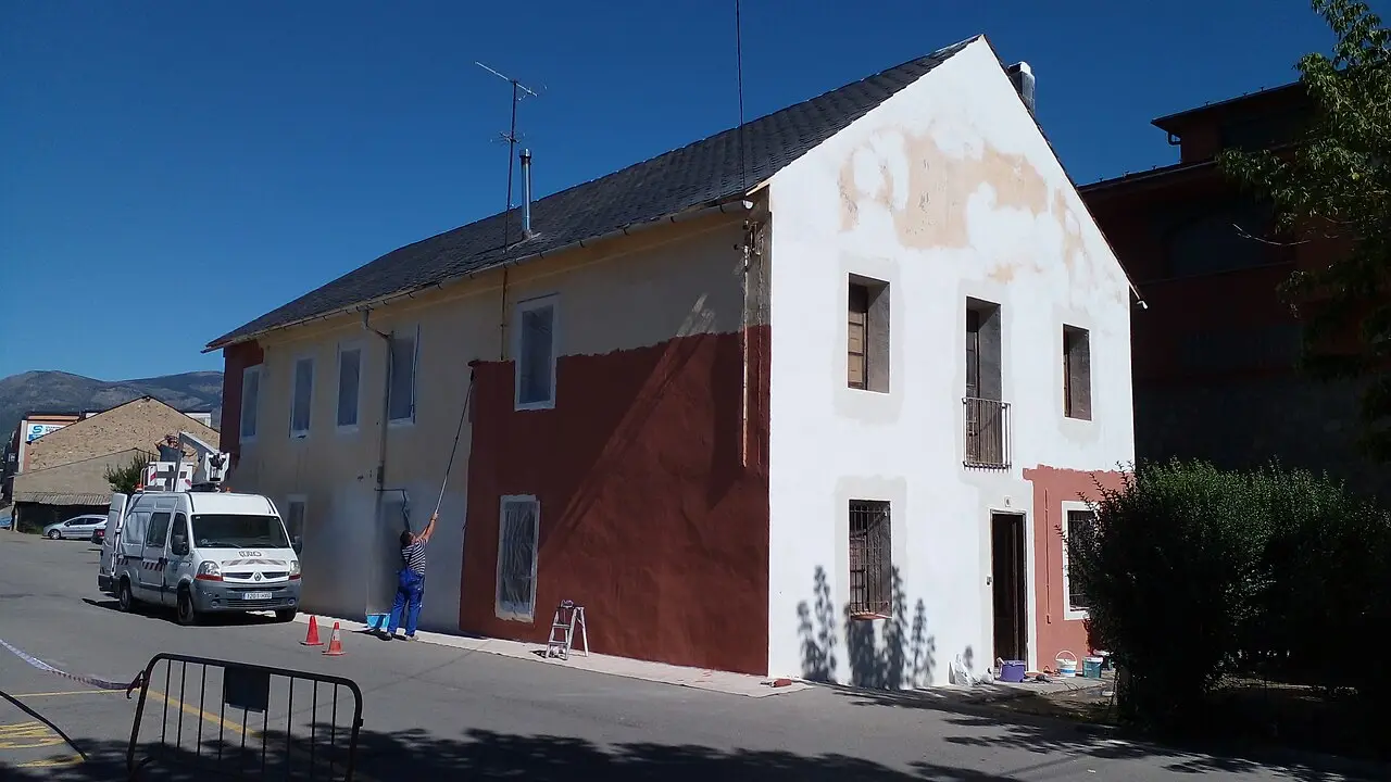 Peintres en bâtiment rénovant une façade